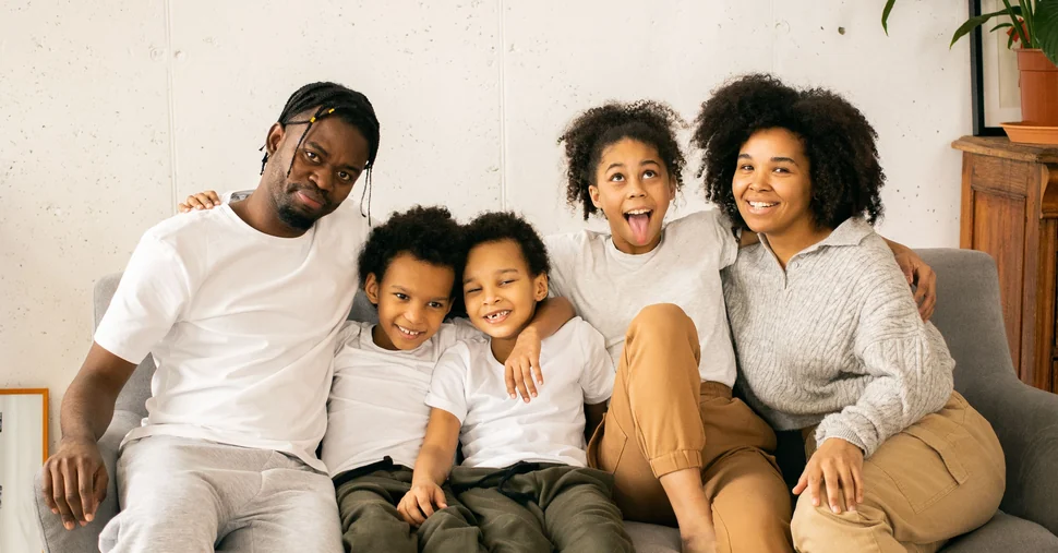 Une famille souriante réunie sur un canapé